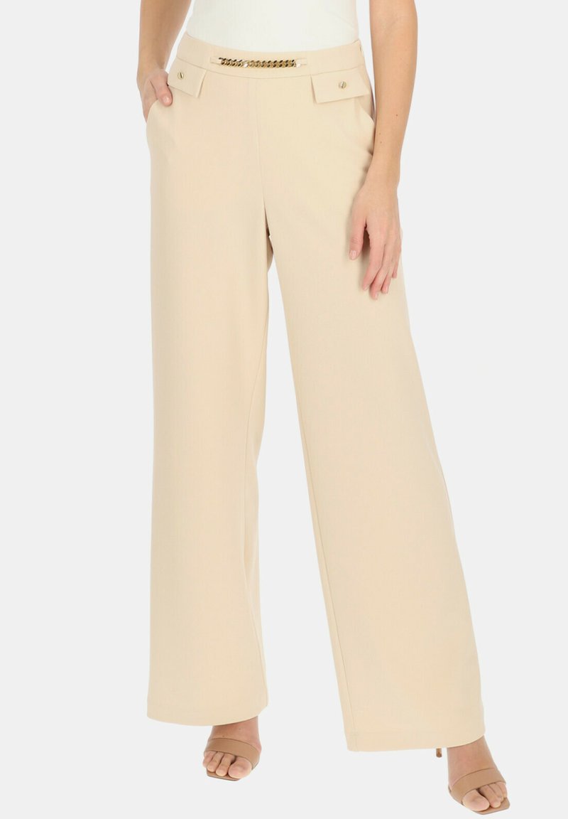 Beżowe spodnie typu wide-leg z miękkiego materiału, posiadające dwie przednie kieszenie, złote akcenty przy pasie oraz gładką fakturę.