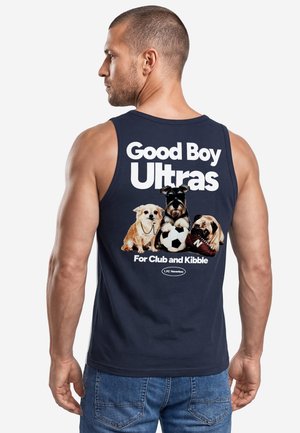 Mann trägt ein marineblaues ärmelloses Shirt mit drei Hunden, einem Fußball und dem Text "Good Boy Ultras For Club and Kibble" auf dem Rücken.
