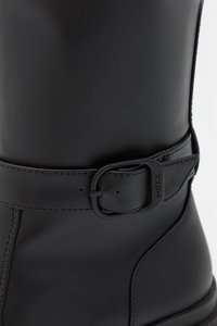 Μαύρη μπότες μέχρι το γόνατο από λείο λάστιχο με ζωνάκι. Περιλαμβάνει στρογγυλή μύτη και κομψό σχέδιο, κατάλλη λο για υγρές συνθήκες.