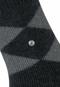 Calze spesse e lavorate a maglia in grigio scuro e grigio chiaro con un motivo geometrico. Bottone con logo argentato sul lato. Texture morbida.