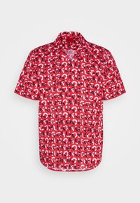 Chemise rouge à manches courtes avec boutons, décorée d'un motif intégral de texte "HUGO" en noir, blanc et rouge sur un fond rouge.