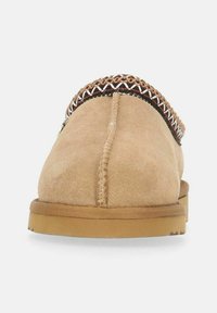 Beige ruskinds slip-on sko med rund tå, dekorativ syning på overfladen og en holdbar gummisål. Accentueret med flette detaljer.
