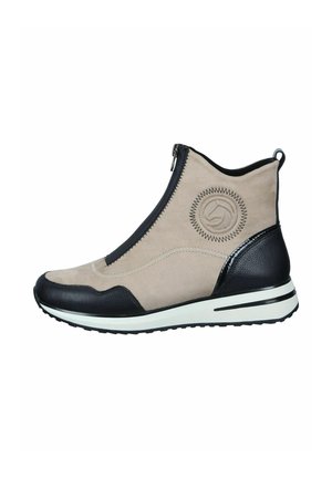 Beige suede ankle boot with black leather accents, side zipper, and decorative stitching. White rubber sole with black stripes.