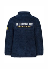 Navyblaue Fleecejacke mit hohem Kragen. Zeigt "FEUERWEHR EINSATZLEITER" in Weiß und Gelb. Verfügt über eine strukturierte, weiche Außenseite.