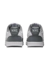 Weiße Leder-Sneaker mit grauen Akzenten, ausgestattet mit einer strukturierten grauen Fersenschlaufe und dem weißen "NIKE"-Logo auf der Rückseite. Klassisches Low-Top-Design.