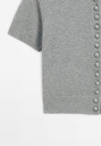 Cardigan corto grigio chiaro a maniche corte, realizzato in tessuto a maglia, con una chiusura a bottoni sul davanti, dettagli arrotondati e orlo a coste.