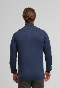 Dunkelblauer Pullover mit hohem Kragen, langen Ärmeln und gerippten Bündchen. Aus einem weichen, strukturierten Stoff gefertigt. Rückansicht gezeigt.
