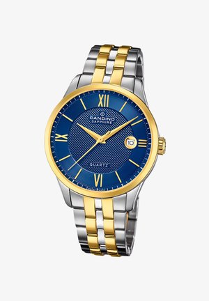 Montre à quartz avec un cadran texturé bleu, index horaires dorés et accents dorés sur le bracelet en acier inoxydable. Affichage de la date à la position 3 heures.