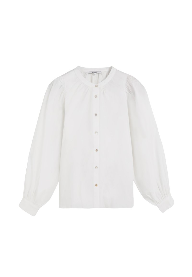 Blusa blanca hecha de una tela suave. Cuenta con mangas largas abullonadas, un cuello redondo y un frente con botones que se abotona, decorado con pequeños botones de color claro.