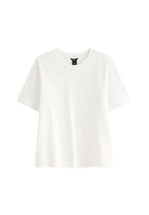Hvid bomulds t-shirt med korte ærmer, rund udskæring og dekorative små perle-lignende accenter jævnt placeret på fronten.