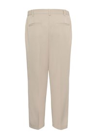 Pantalon beige avec taille élastique, deux poches arrière, jambes fuselées et texture lisse et légère. Confectionné dans un tissu doux.