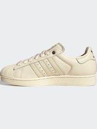 Αντιλευκά δερμάτινα χαμηλά παπούτσια Adidas με λαστιχένια μύτη κέλυφος, τρεις πλαϊνές ρίγες και κλείσιμο με κορδόνια, εμφανιζόμενα από την εξωτερική πλευρά.