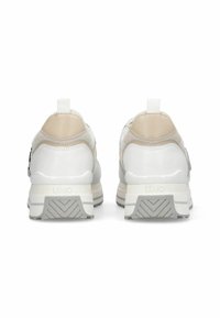 Chaussures de sport blanches et beiges avec une tige en mesh texturé, un talon renforcé, un marquage minimaliste et une semelle en caoutchouc épaisse et à motifs.