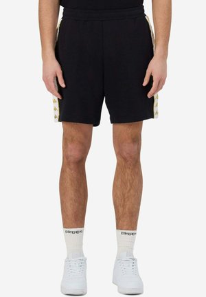 Pantaloni corti neri realizzati in tessuto morbido, con strisce laterali con un motivo giallo e una vita elastica per il massimo comfort.