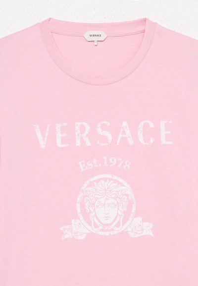 Φωτεινό ροζ T-shirt Versace με λευκό λογότυπο σε σκισμένη μορφή, έμβλημα κεφαλής Μέδουσας και την επιγραφή "Est.1978" στο μπροστινό μέρος του λαιμού.
