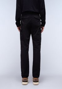 Black cargo pants featuring a straight leg design, multiple side pockets, and a soft fabric texture. Worn with beige shoes and a black top.