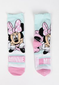 Calzini di Minnie Mouse in verde menta, con un fiocco a pois rosa, dettagli neri e testo "MINNIE" in rosa, dal texture morbido.