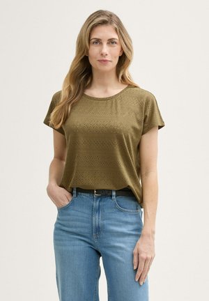 Chemise à manches courtes vert olive avec un motif texturé, col rond, coupe décontractée, associée à un jean en denim bleu clair et une ceinture noire.
