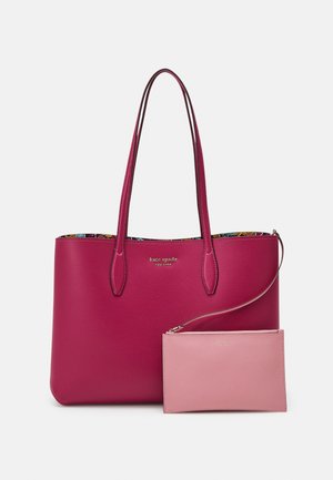 Sac fourre-tout en cuir rose foncé avec de longues poignées et une petite pochette bracelet rose clair attachée à l'avant.