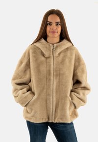 Giacca in pelliccia sintetica beige con cappuccio, zip frontale e maniche ampie e morbide. Presenta una texture liscia e due tasche laterali.