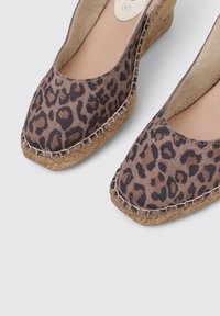 Zapatos espadrilles con estampado de leopardo, suela de yute trenzado, punta redonda y un forro de cuero suave. Presentan detalles cosidos a lo largo del borde.