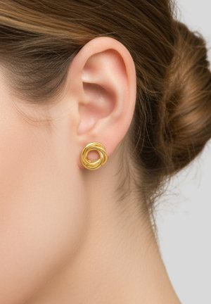 Gouden ronde oorbellen met een gelaagde spiraalontwerp, voorzien van een gepolijste afwerking en een gladde textuur, gedragen aan de oorlel tegen een lichte achtergrond.