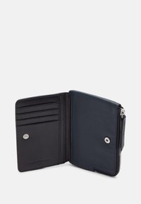 Portefeuille en cuir navy avec une finition texturée, comportant des emplacements pour cartes, un fermoir à pression et un compartiment zippé pour les pièces.