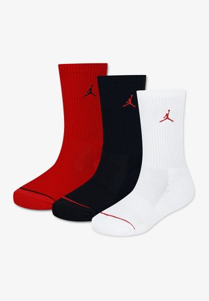 Tri podkolienky v červenej, čiernej a bielej farbe, každá s malým logom Jumpman blízko vrchu.