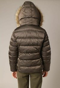 Doudoune marron avec des sections matelassées horizontales, une capuche doublée de fourrure et des poignets élastiques. Le matériau semble brillant et lisse.