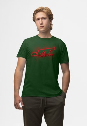 Grøn kortærmet t-shirt i bomuldsstof med et stort rødt "JT Racing" grafik foran med en tekstureret baggrund.