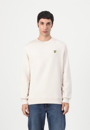 Sweatshirt beige clair en matériau doux avec un col rond et des poignets côtelés. Présente un petit logo de papillon jaune sur la poitrine.