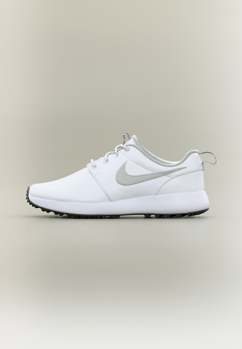 White athletic shoes with a textured surface, gray accents, and round laces. Features a logo on the side and a black rubber outsole.