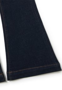 Jeans de mezclilla oscura de corte acampanado con dobladillo sin terminar, que presentan costuras en naranja contrastante a lo largo de las costuras, ofreciendo una apariencia texturizada y resistente.