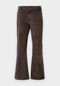 Pantalon évasé en velours côtelé marron avec passants de ceinture, bouton à l'avant et fermeture éclair sur fond blanc.