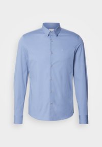 Camicia button-up a maniche lunghe di colore azzurro chiaro, con colletto e piccolo logo ricamato bianco "ck" sul lato sinistro del petto.