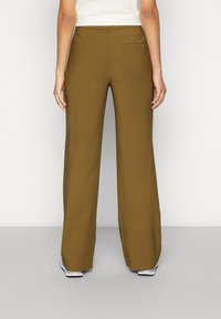 Breda byxor i olivgrön tyg, med en jämn textur, två bakfickor och design med hög midja.