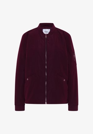 Veste bomber bordeaux avec fermeture éclair sur le devant, deux poches à rabat avec bouton, col et poignets côtelés, et poche zippée sur la manche gauche.