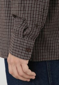 Chemise à carreaux marron et blanc avec des poignets à boutons, dotée d'un tissu texturé, coupe droite et d'un riche contraste de couleurs.