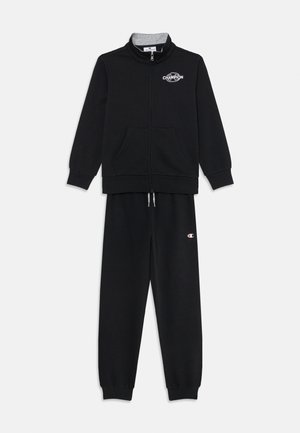 Tuta nera con zip, dotata di colletto alto, due tasche frontali e dettaglio con logo. Tessuto morbido con polsini e vita a coste.