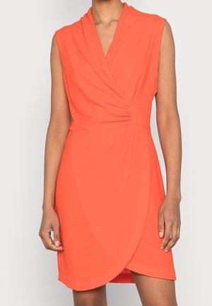 Robe sans manches de couleur orange vif avec un devant style portefeuille et un léger détail froncé à la taille, portée par une personne sur un fond uni.