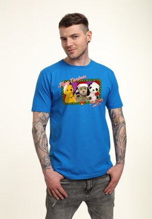 Blå bomulds T-shirt med et festligt motiv af tre plysdyr iført nissehuer, indrammet af en grøn blomsterkant og teksten "Glædelig jul".