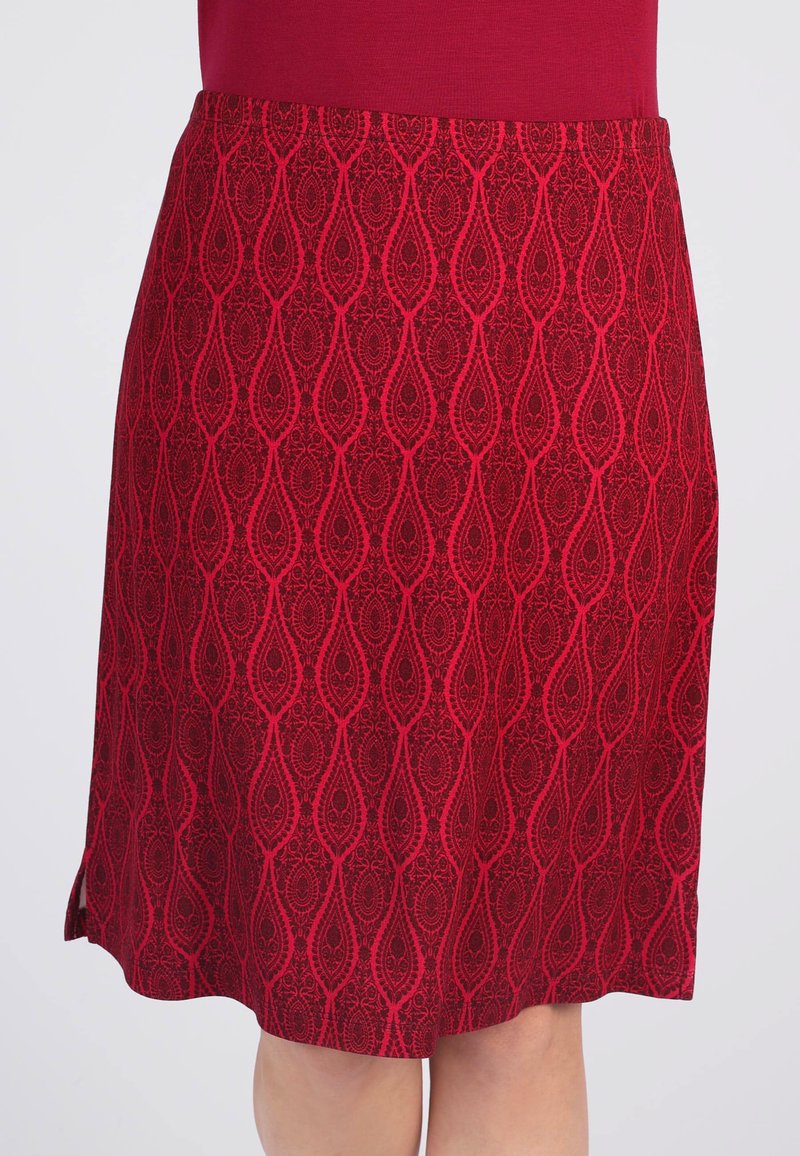 Roter knie-langer Rock mit einem strukturierten Muster aus Paisley-Formen. Glattes Material mit seitlichen Schlitzen, die eine fließende Silhouette erzeugen.