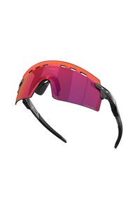 Occhiali da sole con montatura arancione e lenti rosa. Il design presenta una forma curva e bracci sottili, neri e testurizzati con ritagli.