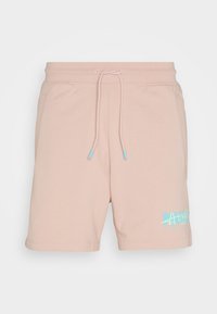 Shorts décontractés rose clair avec taille à cordon, poches latérales et logo graphique bleu sur la partie inférieure de la jambe gauche.
