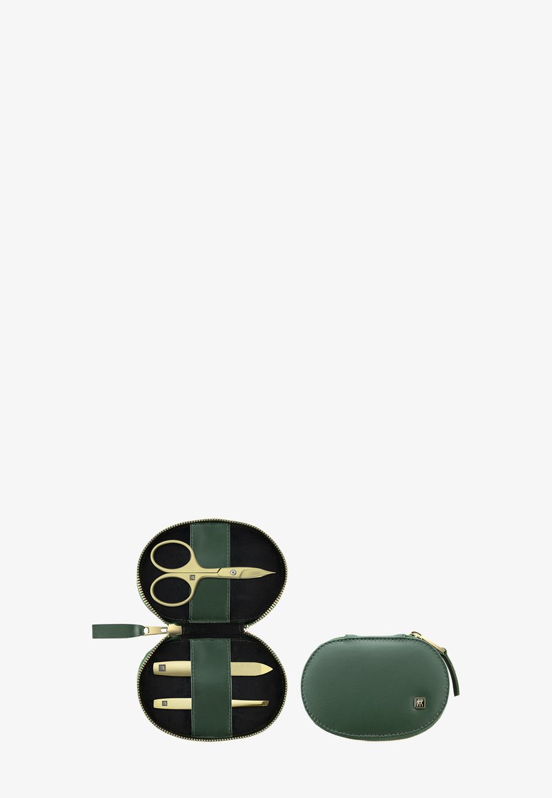 Groene leren ritstas met gouden scharen, nagelvijlen en een klein ovale pouch. Het interieur heeft een zwarte voering.
