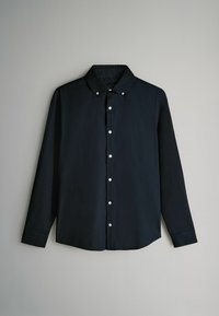 Tumši zila auduma krekls ar garām piedurknēm un pogām. Iezīmēta ar klasisku apkakli, baltām pogām un taisnu apakšmalu ar aprocēm.