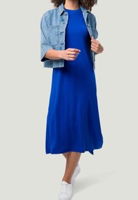 Sininen jerseymekko, jossa onlaaja muotoilu, täydentää vaalean denimgin pituisella takilla. Täydentää asukokonaisuutta valkoiset lenkkarit, luoden rentoa ilmettä.