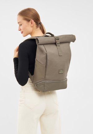 Taupe színű anyagból készült roll-top hátizsák, szürke díszítéssel, elülső zsebbel és állítható pántokkal. Simító felület, strapabíró kialakítás.