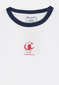 Λευκό βαμβακερό μπλουζάκι με μπλε ναυτικό ριμπ γιακά, με κόκκινο λογότυπο Champion και το κείμενο «Authentic Athleticwear» στο μπροστινό μέρο ς.