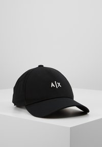 Gorra de béisbol negra hecha de algodón, con un logotipo bordado en blanco "A/X" en la parte frontal, con una corona redondeada y visera curva.